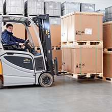 Centos Lagerhalle mit Gabelstapler, der Kisten hebt